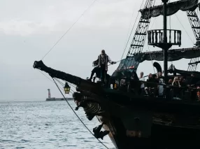 a group of people standing on top of a pirate ship